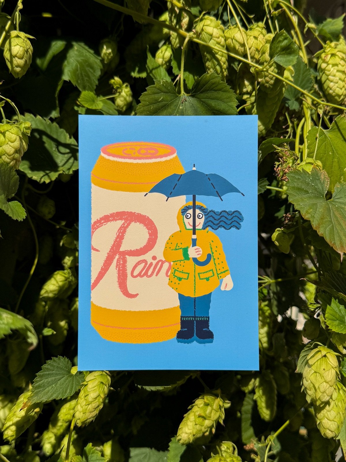 A Wug Prints postcard tucked among fresh hop vines